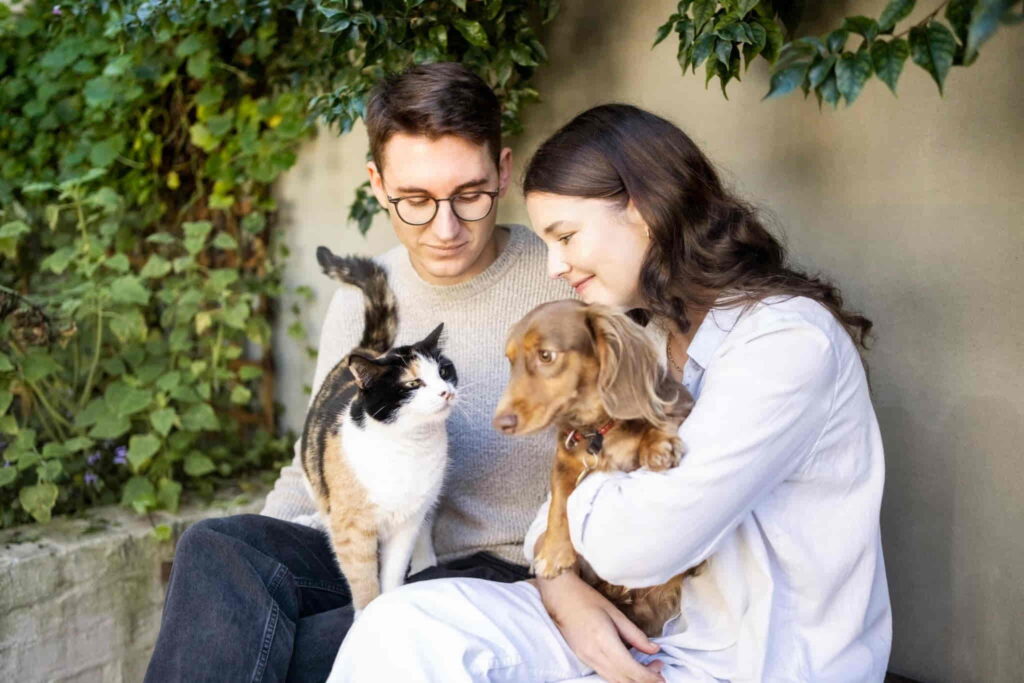 a cute family of a dog, cat and a couple